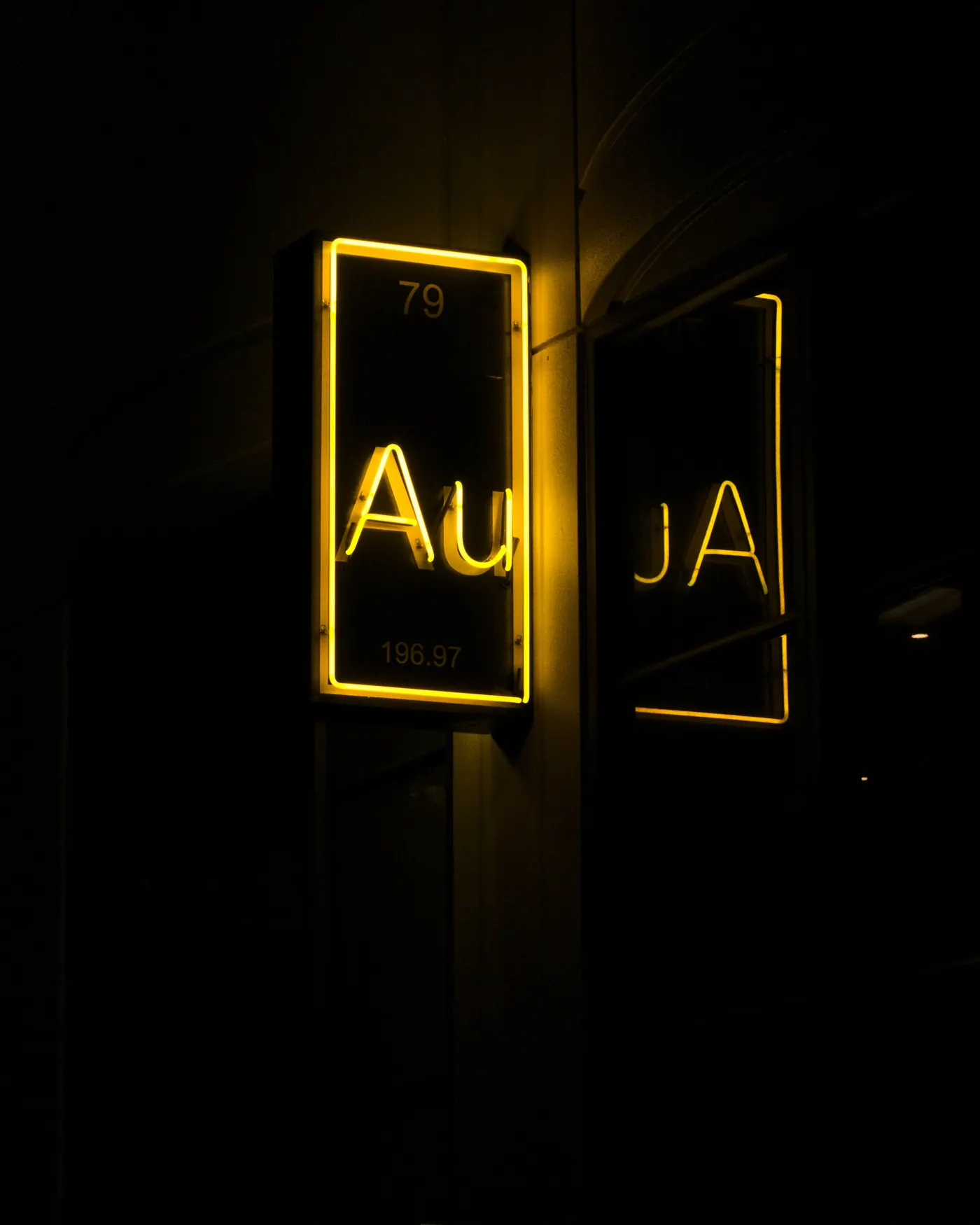 A neon sign reading Au, the chemical symbol for gold, glowing in the dark
